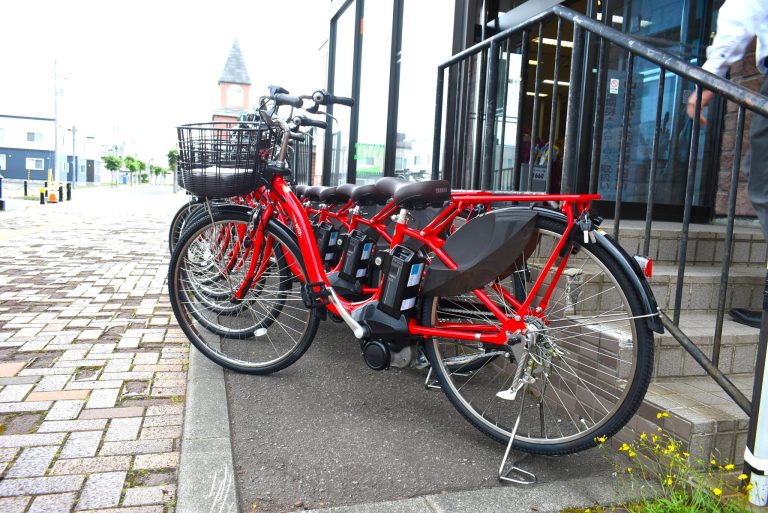 余市観光協会前に置かれた赤い電動自転車の写真